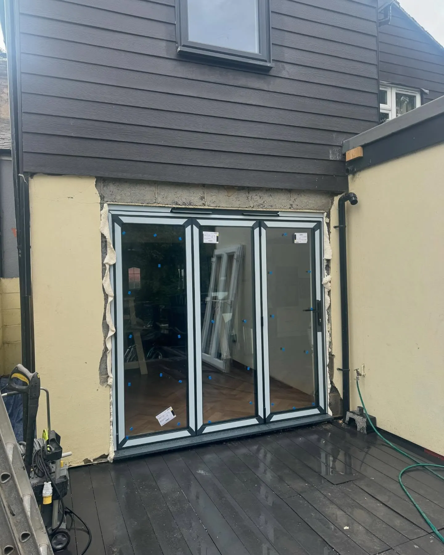 Black framed bifold doors installed with the protective film still on
